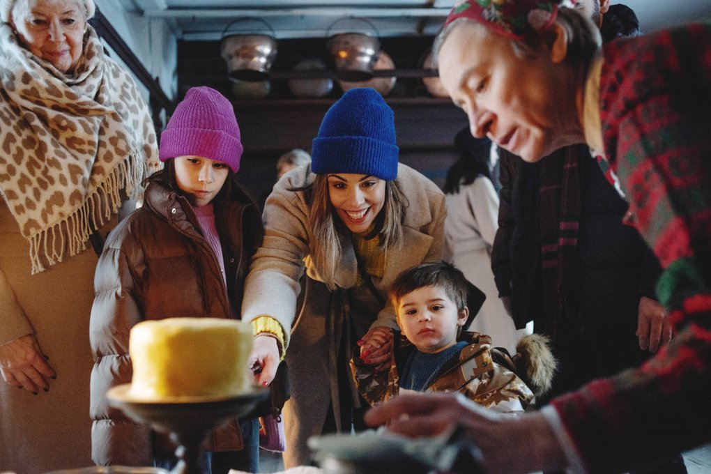 A group of happy visitors leaning over a table in an old building.