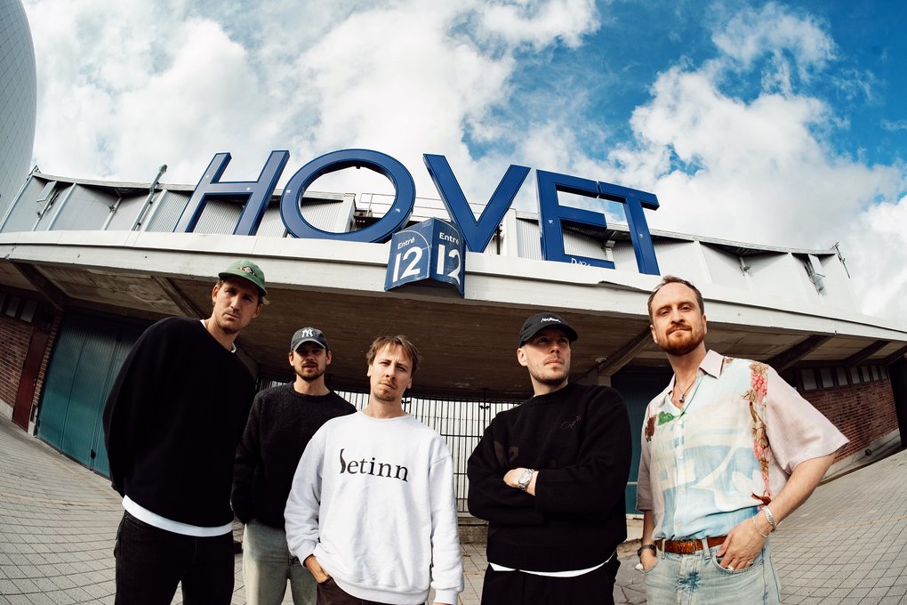 Fisheye view of five men standing outside a hockey arena.